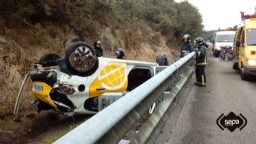 Bomberos de Llanes con el turismo accidentado en la A-8.