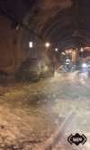 Bomberos con el coche incendiado en el interior del túnel de Pando, Lena.