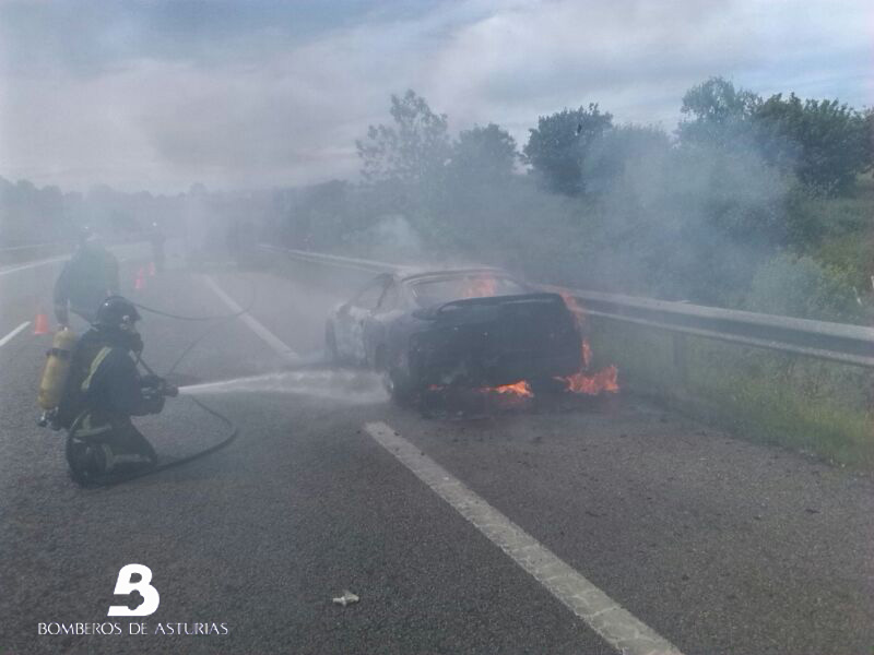 Los bomberos sofocando las llamas del vehculo