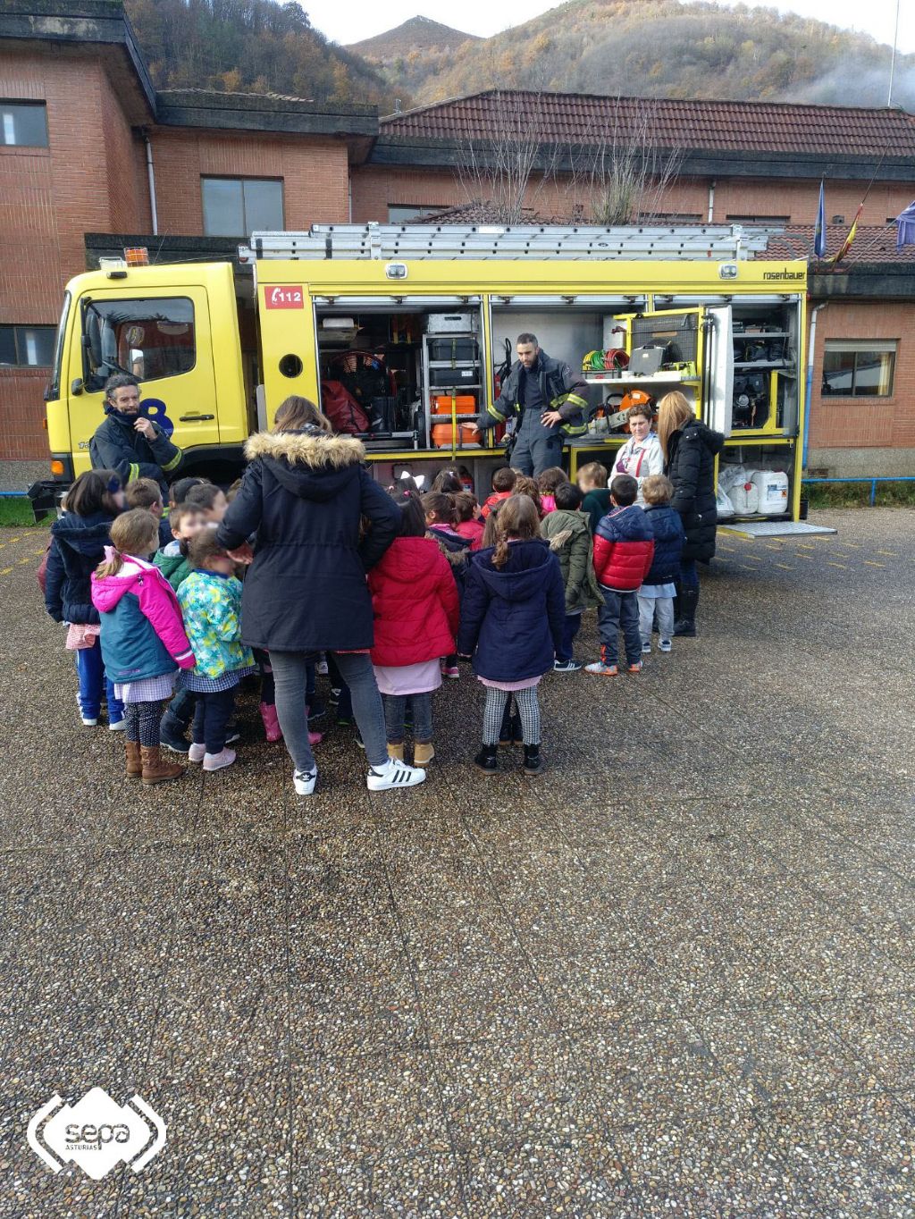 Los bomberos con alumnos y profesores tras el ejercicio