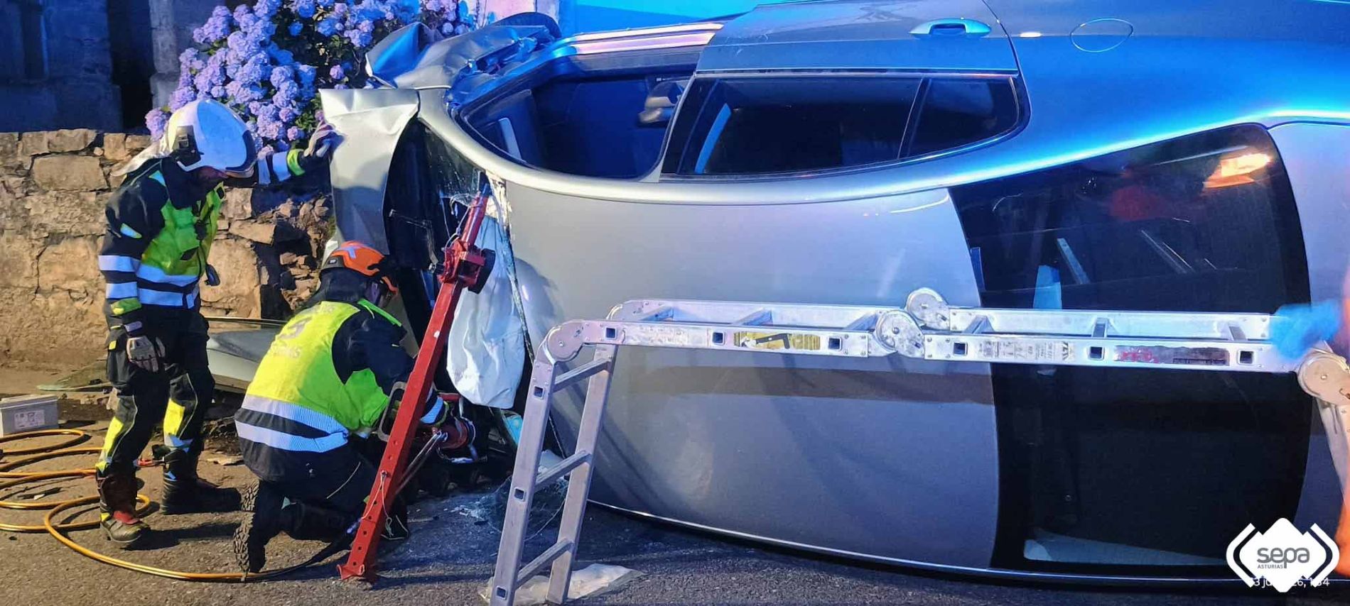 Bomberos de Tineo con el coche accidentado en El Pedregal.