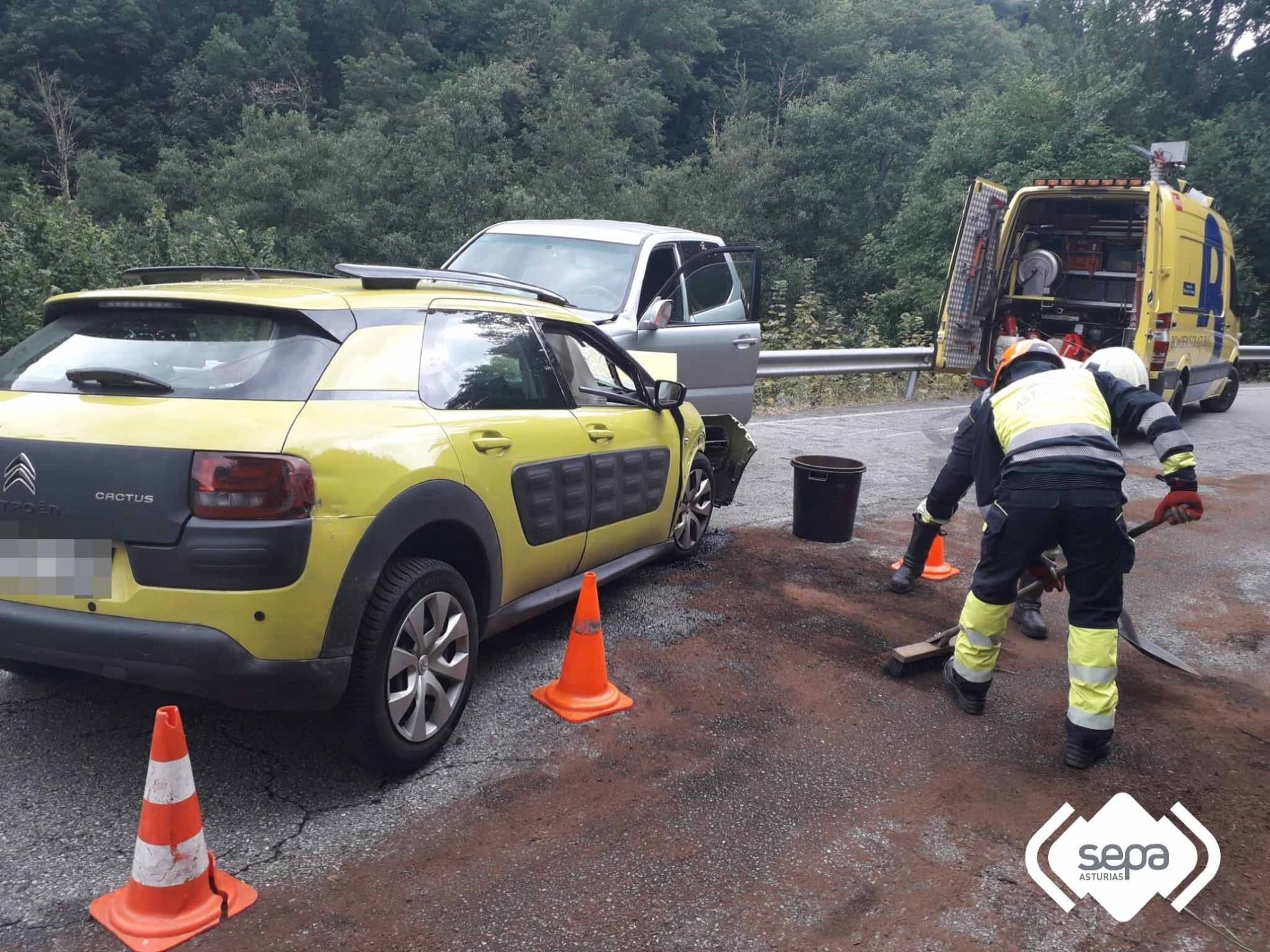 Bomberos en tareas de limpieza de la calzada en la AS-15.