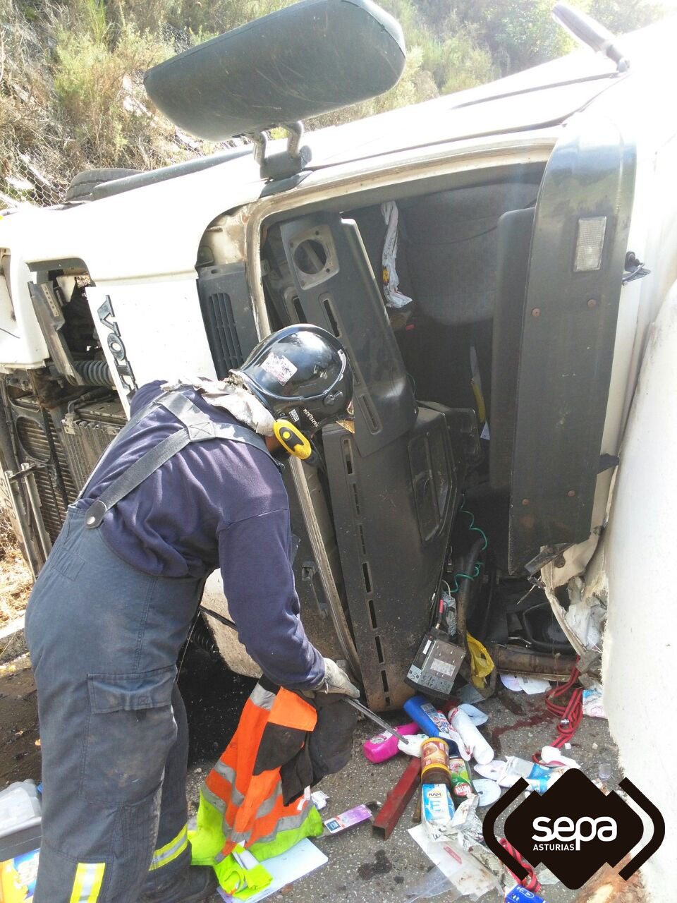 Bomberos con el camin accidentado en Santa Eulalia de Oscos.