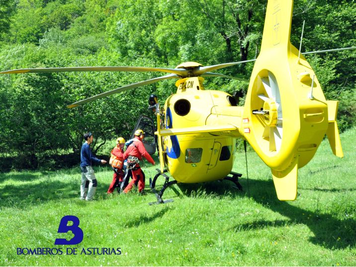 Momento en el que el menor es evacuado al helicóptero acompañado por el médico y los rescatadores del equipo de Bomberos de Asturias