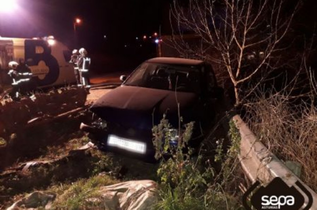 Bomberos de Valdés y el coche accidentado en Coaña.
