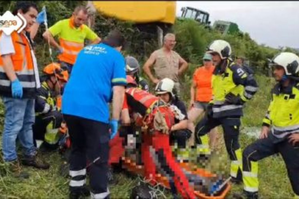 Bomberos y sanitarios con el accidentado por el tractor en Allande.