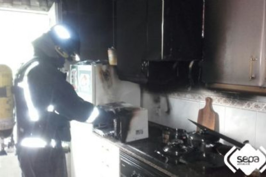 Un bombero en la vivienda afectada por el incendio en Grado.